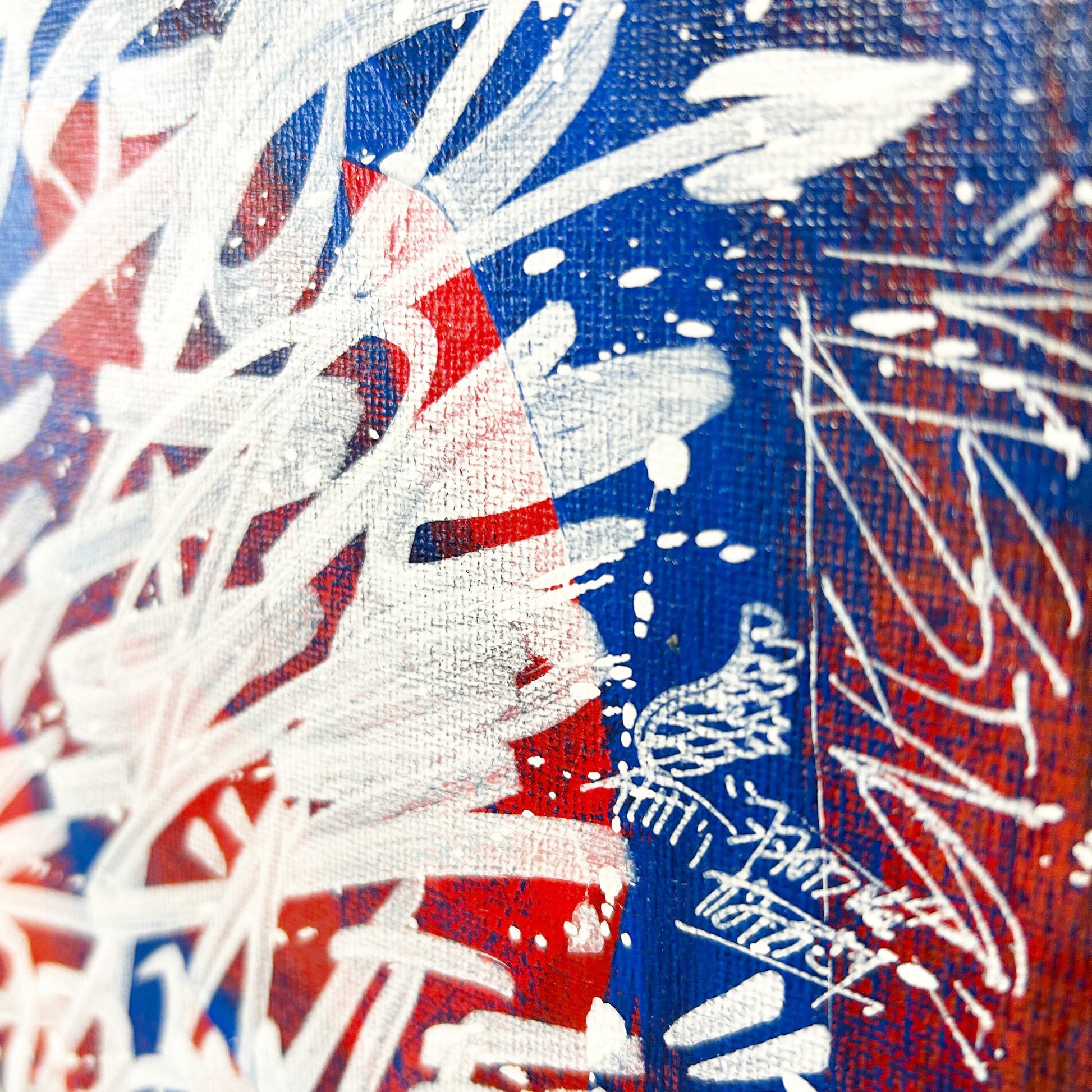 A further zoomed-in photo of the painting. This close-up shot captures the texture of the canvas, with lyrics written in white against a blue and red background.