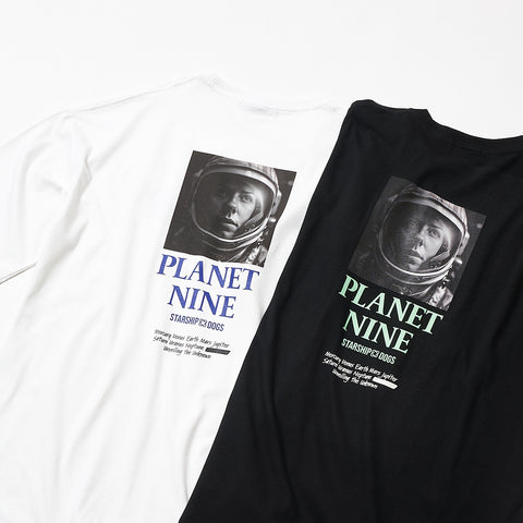 Product Color Variation Photo: On the left, a white T-shirt (print includes a monochrome photo of a female astronaut, 'PLANET NINE STARSHIP DOGS' in blue text, solar system names, etc., in black text). On the right, a black T-shirt (print includes a monochrome photo of a female astronaut, 'PLANET NINE STARSHIP DOGS' in light green, solar system names, etc., in white text).